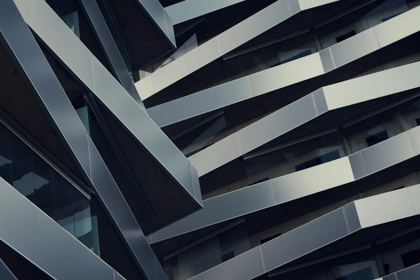 Angular balcony soffits and glass balustrades stacked across a building envelope