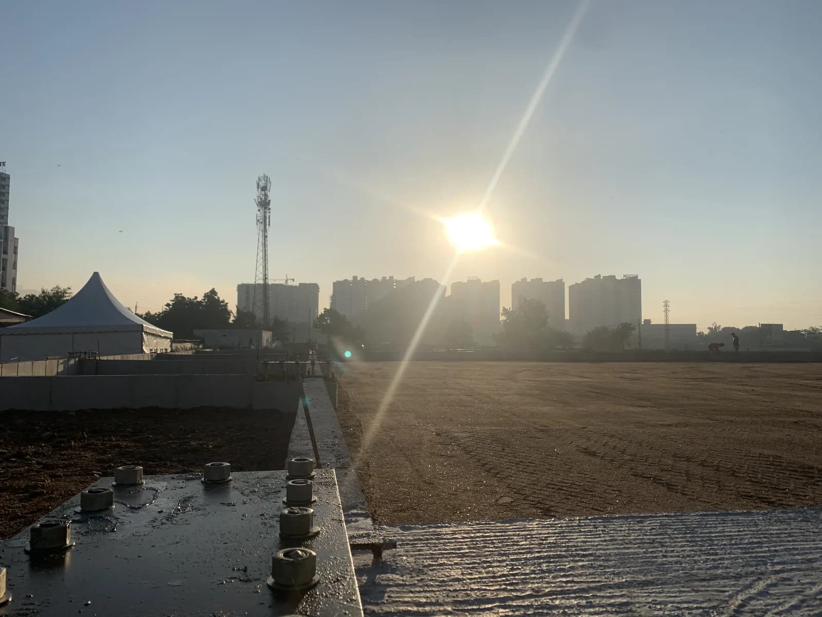 The site at sunset, standing water across the levelled ground