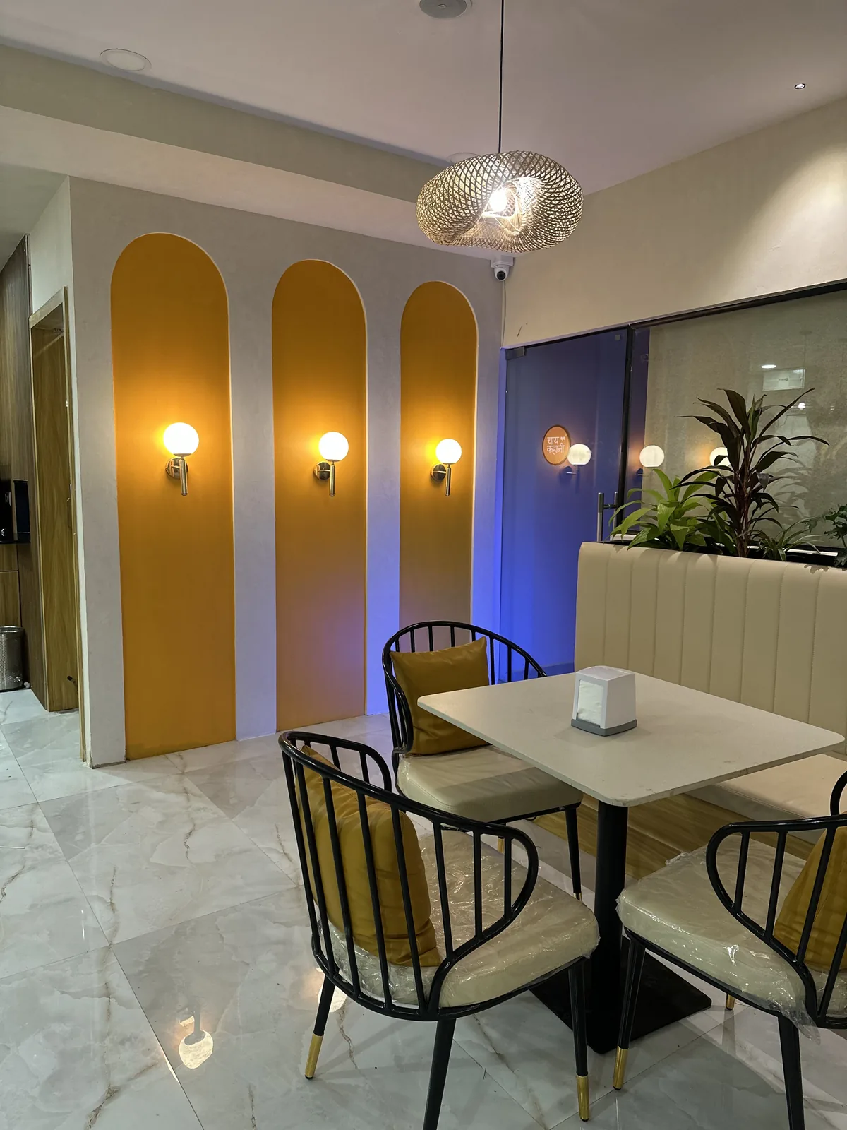 Lit arched alcoves along the cafe wall beside a marble-topped table