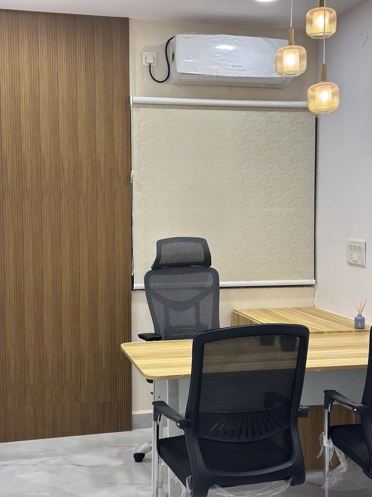 A small meeting room with a fluted timber wall and a shared desk