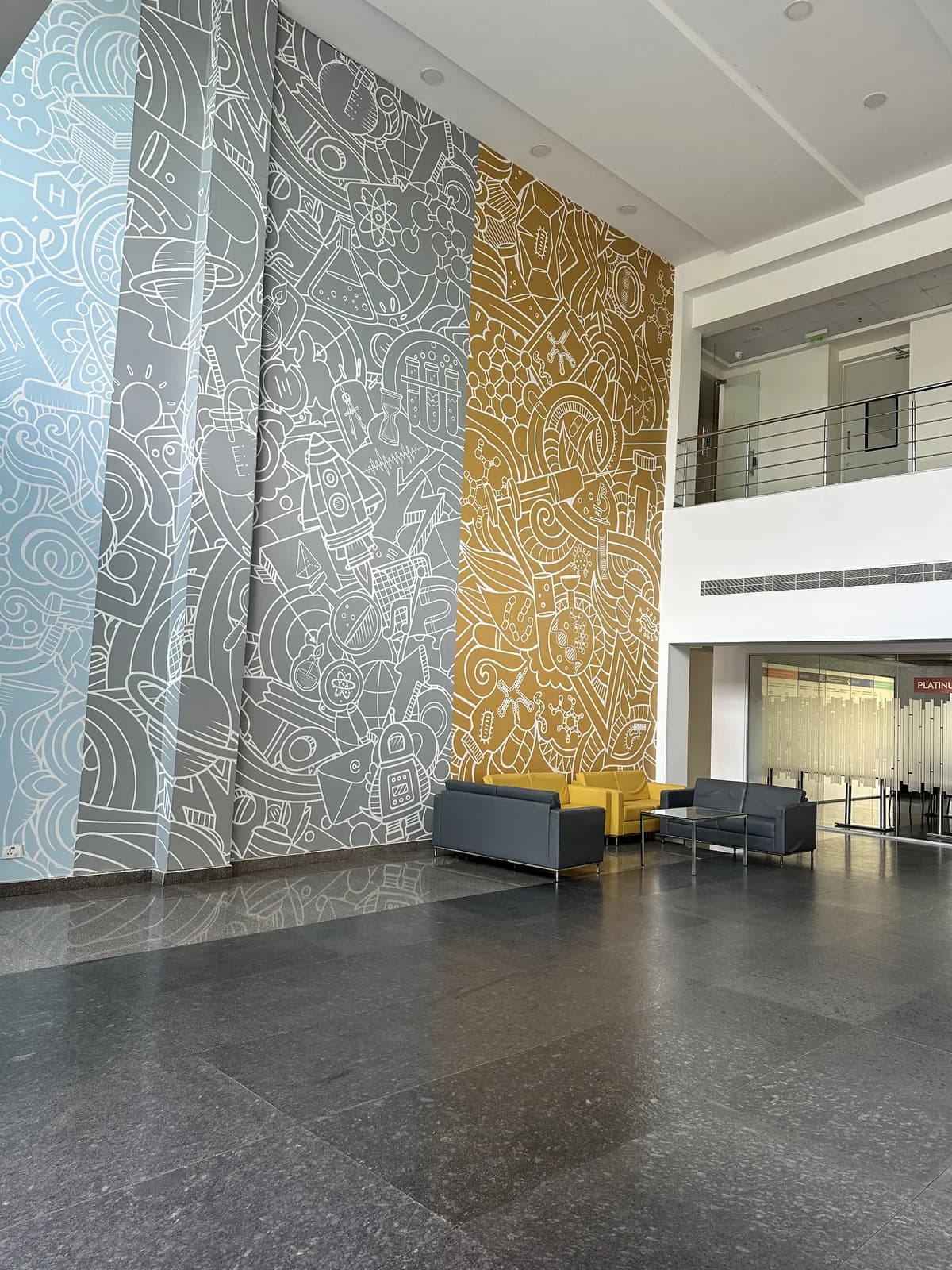 A full-height wall of fine line-drawn ornament in white and gold, beside a stair