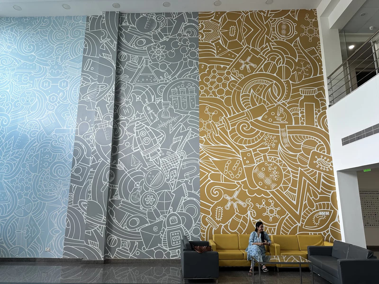 An atrium wall in patterned blue and ochre panels rising the full height