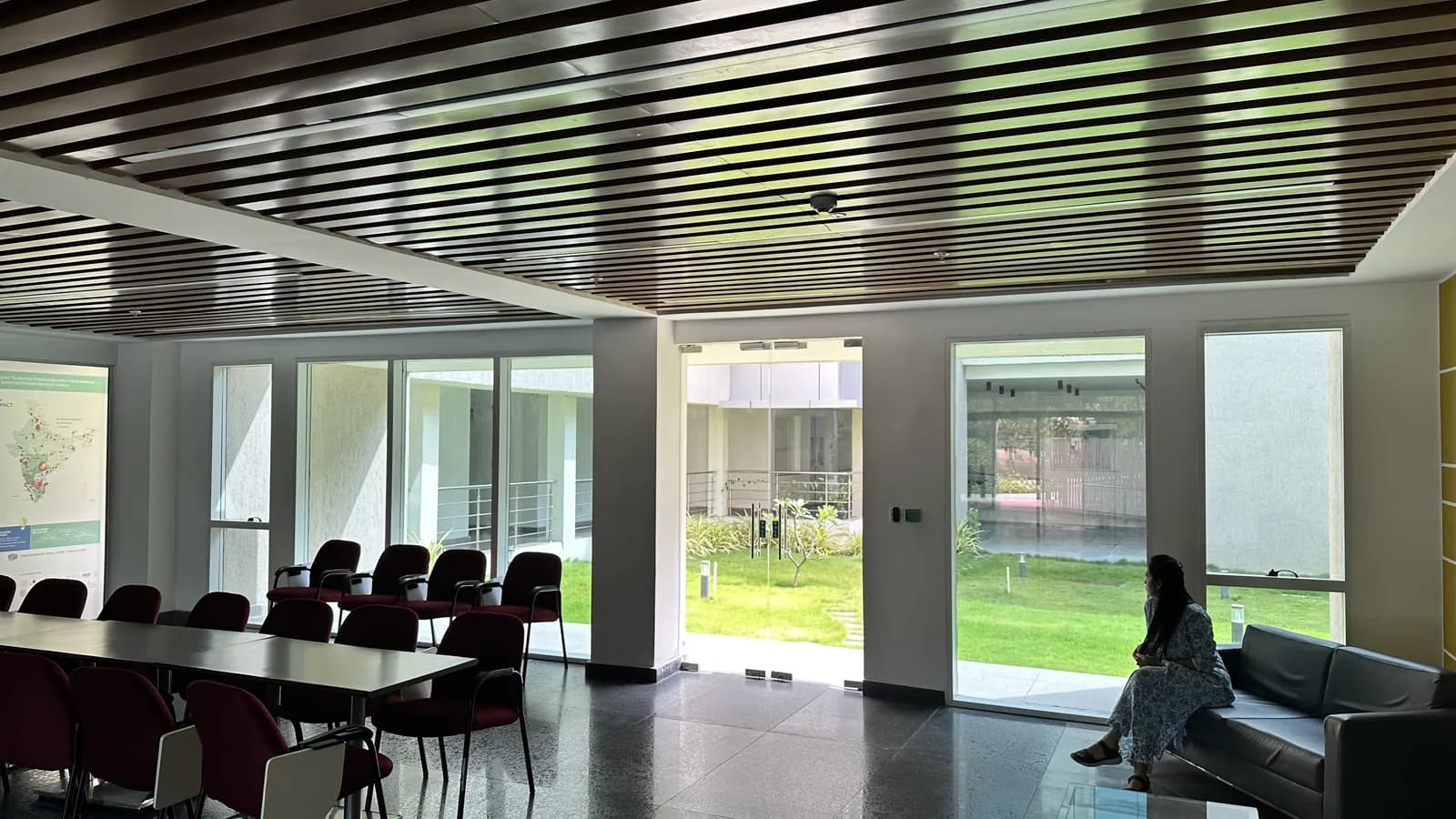 A meeting room with tables and chairs opening to the lawn
