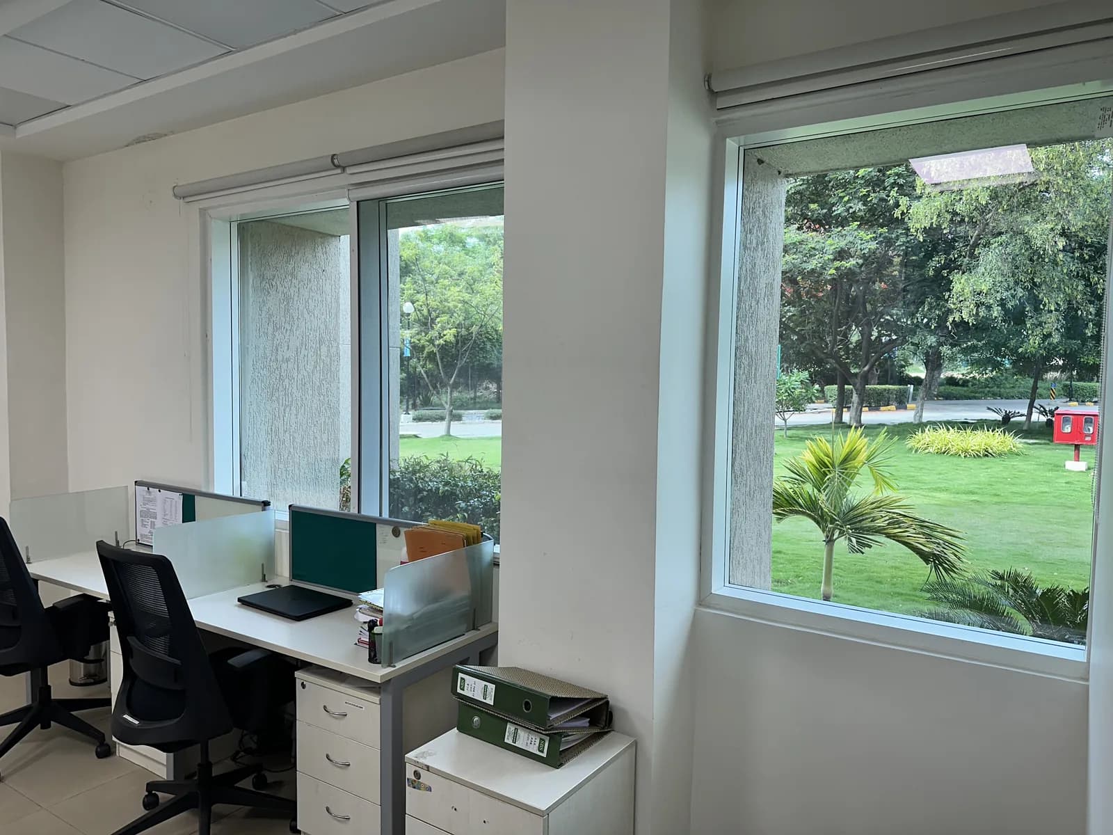 A small office with corner glazing onto the garden and a single workstation