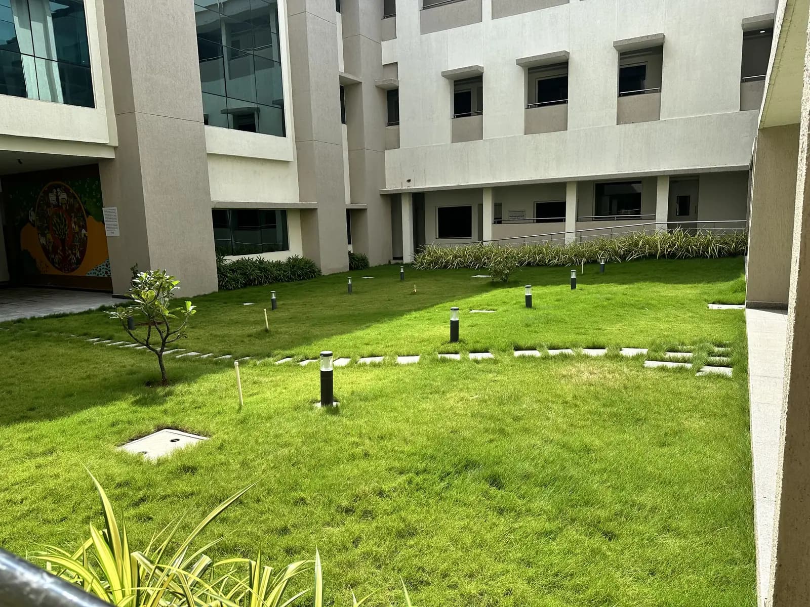 A courtyard lawn with lighting bollards between laboratory blocks