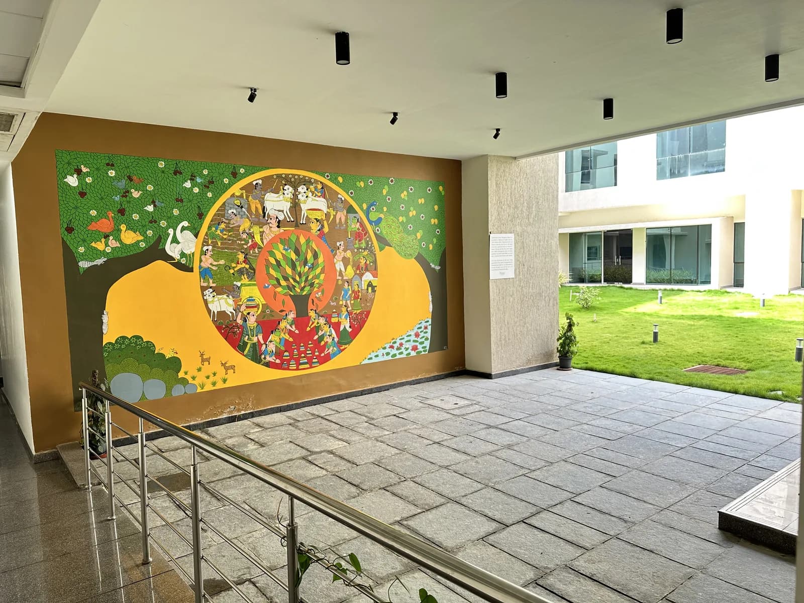 A painted mural at the courtyard edge beside the covered walk