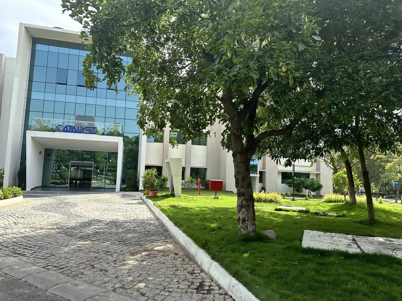The entrance elevation seen across the lawn, framed by a tree