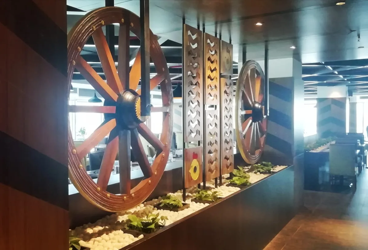 Cart wheels and pierced timber screens standing above a planted trough