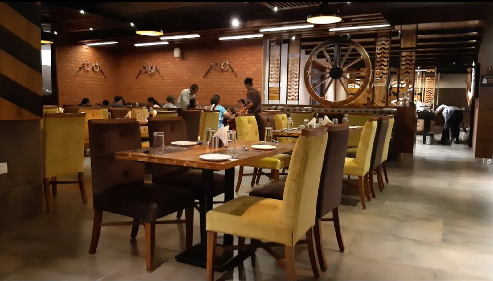 A dining room in timber with high-backed chairs and a cart wheel screen