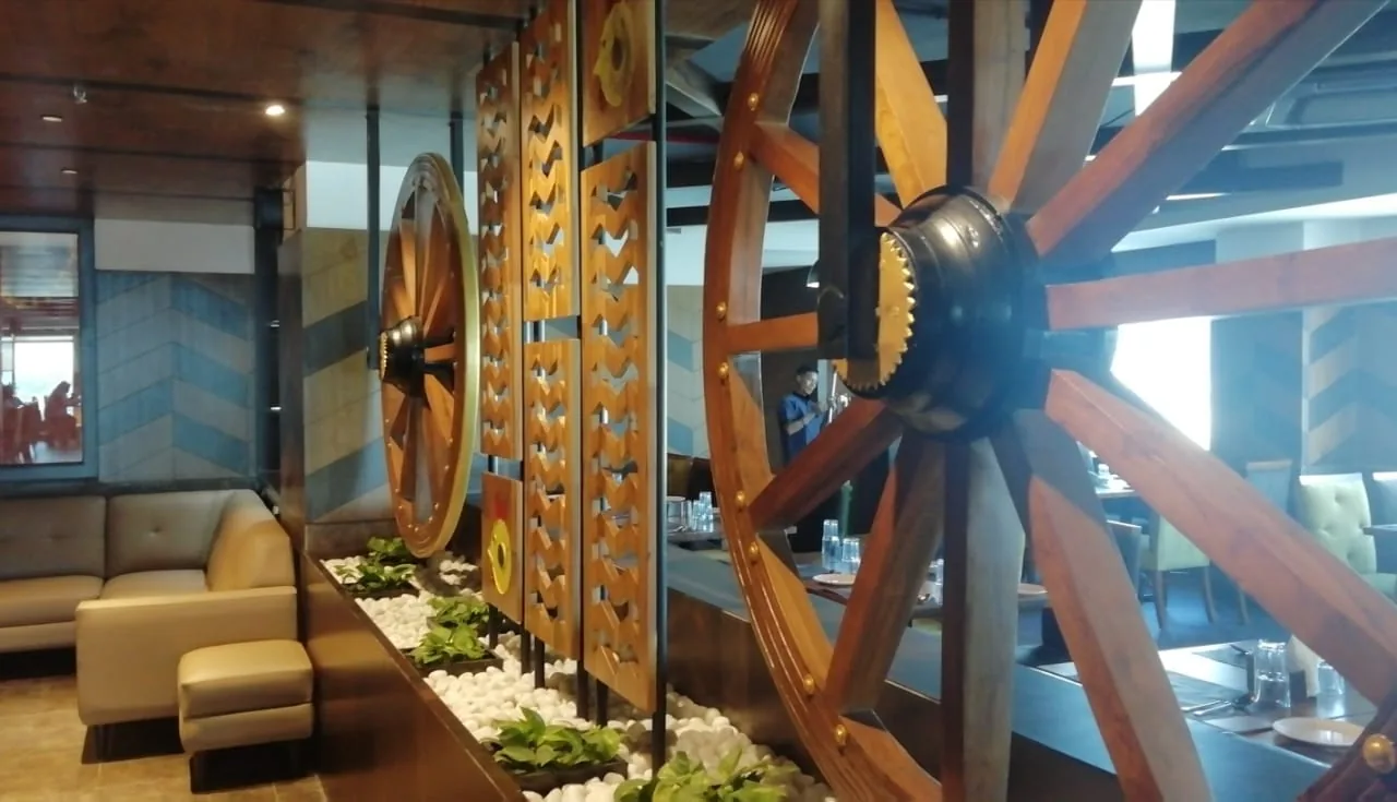 A waiting seat beside a cart wheel and a pebble bed