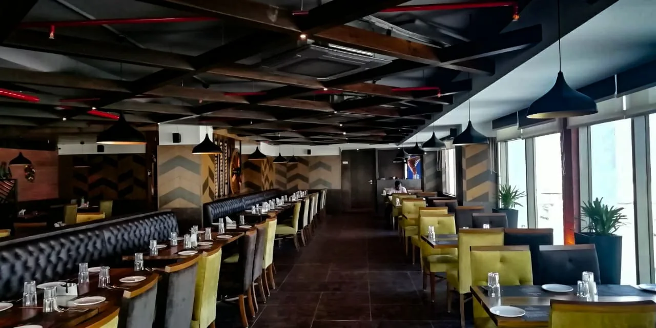 A long dining room lined with booths under a dark battened ceiling