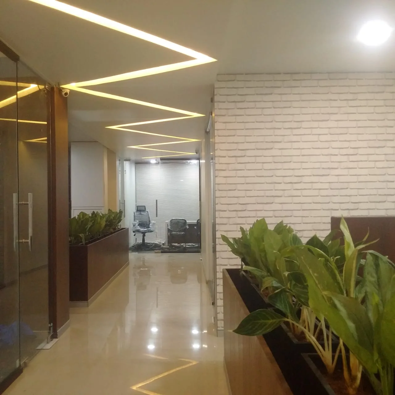 A corridor with light lines leading toward the open office