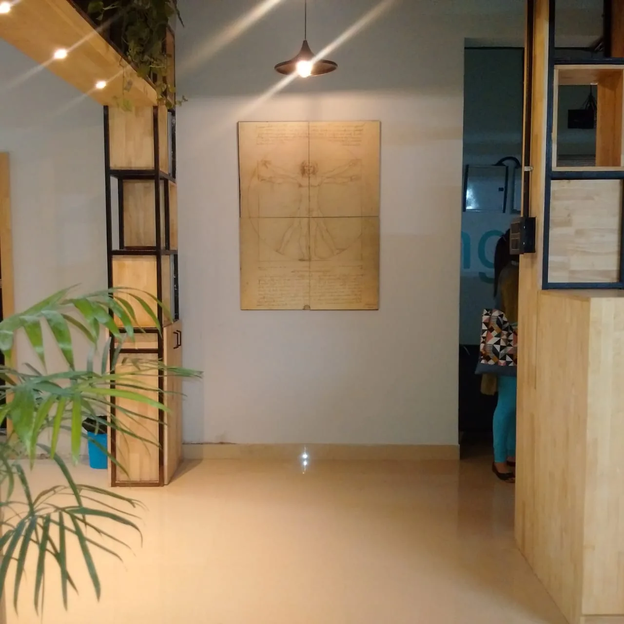 An entrance lobby with a framed drawing between shelving bays