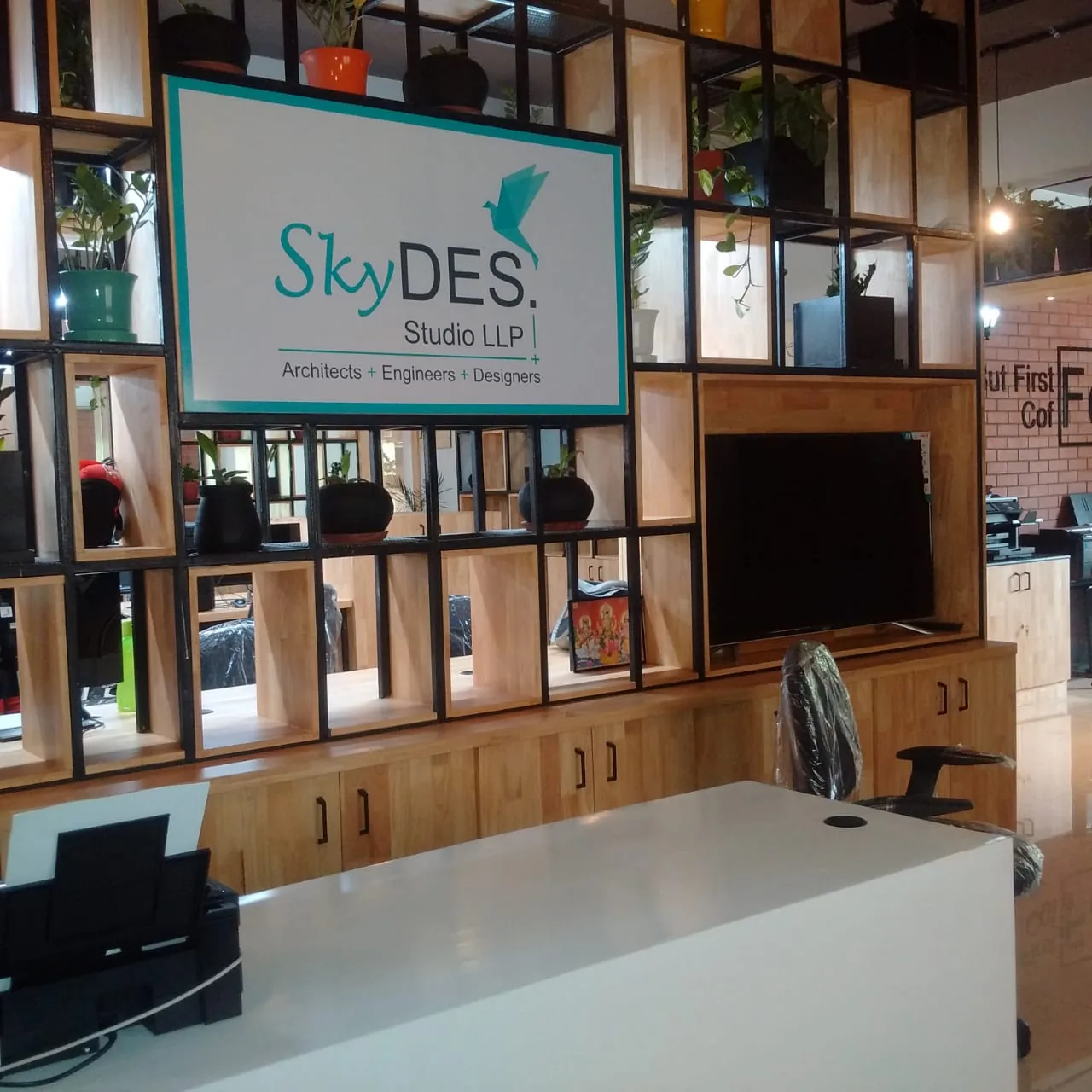 A reception counter beneath the studio sign, set into shelving