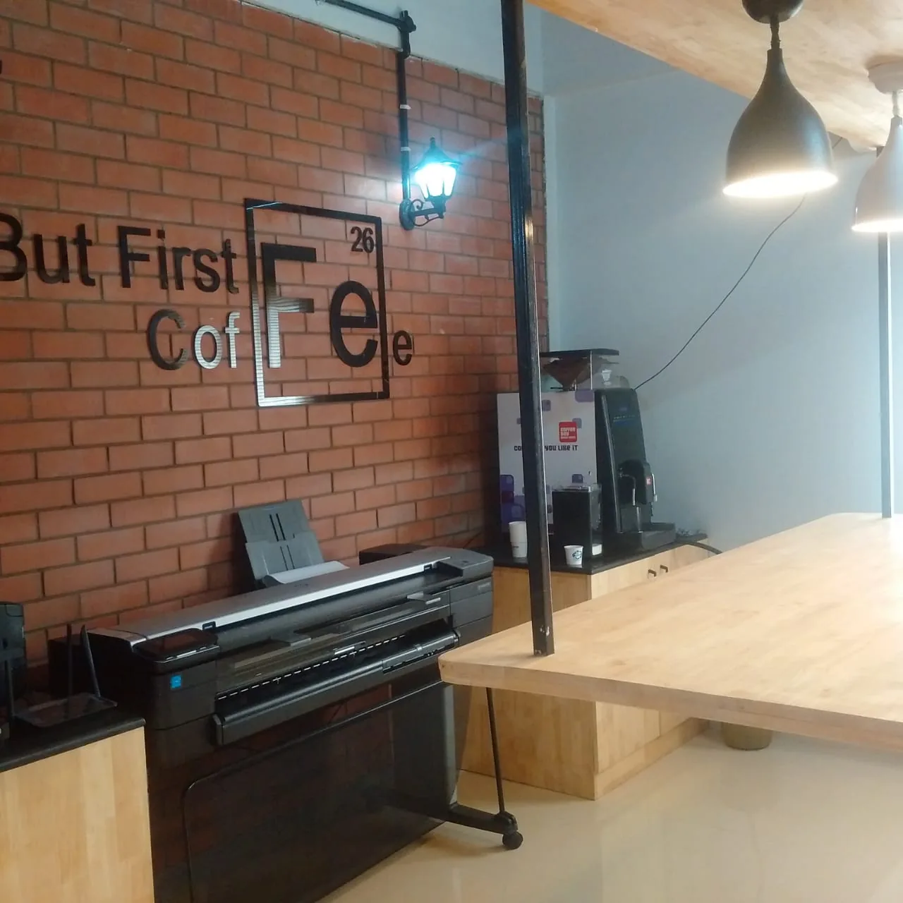 A coffee point with an upright piano below a brick wall graphic