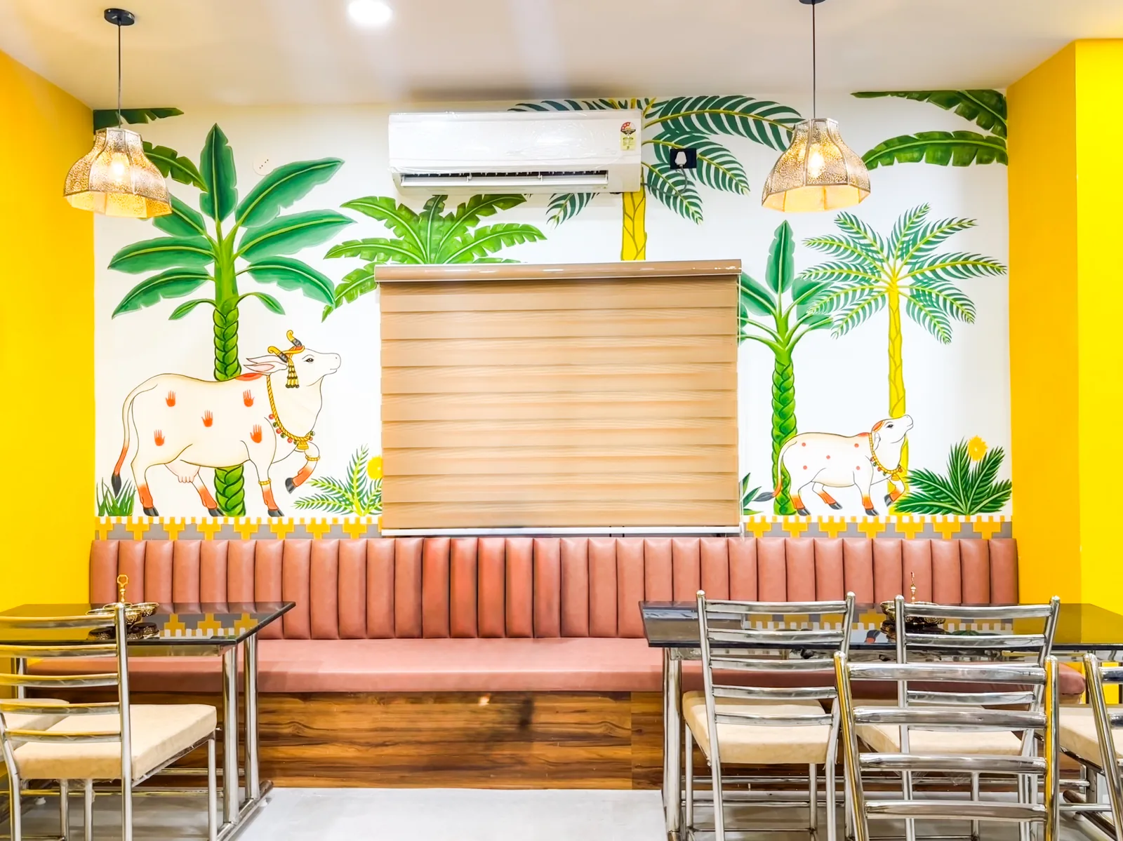 A fluted banquette below a hand-painted mural of palms and cattle
