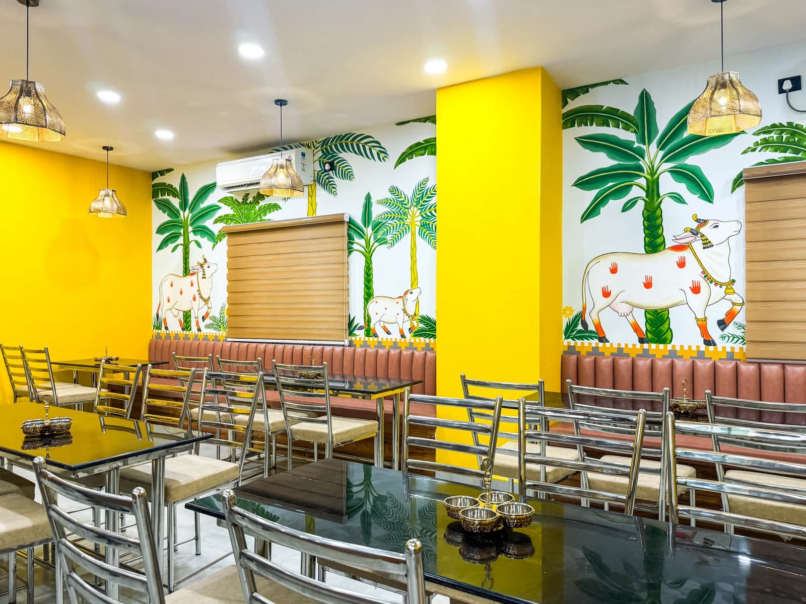 A dining room with the mural wall running along steel-framed tables