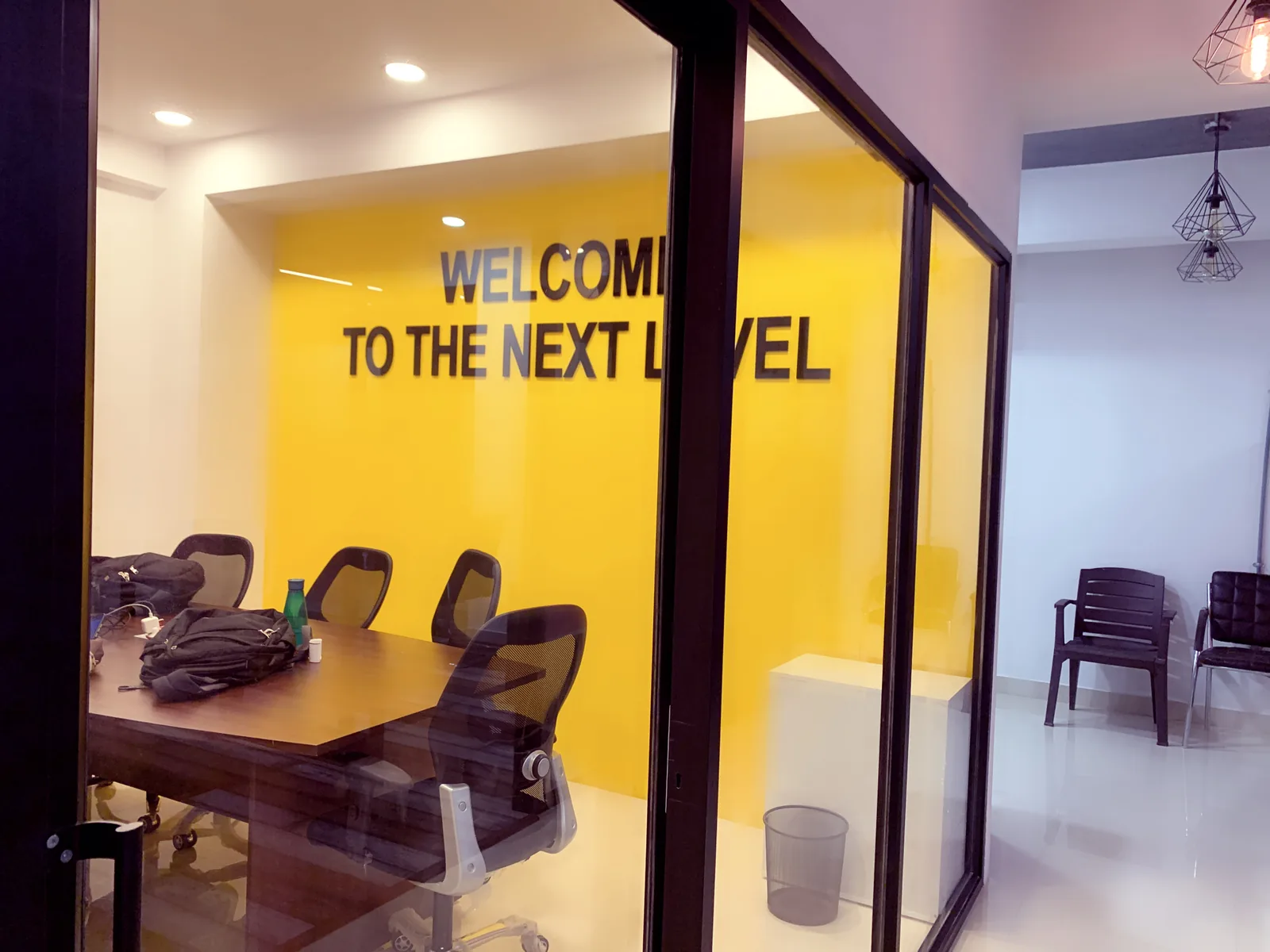 A meeting room seen through glazing, a timber table and chairs inside